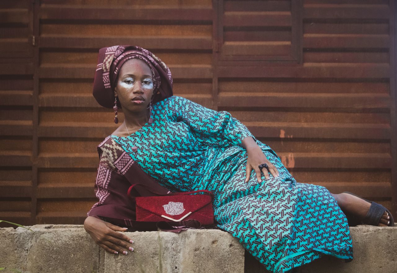 Portrait of a woman in Nigerian attire, showcasing traditional fashion in an outdoor setting.